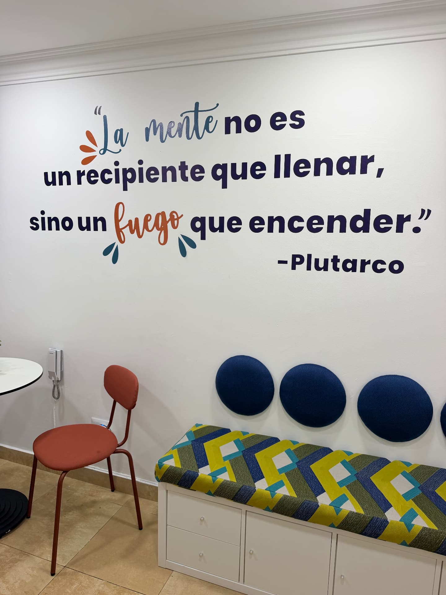 Fotografía real del banco de EDUSER y la frase de Plutarco en la pared
